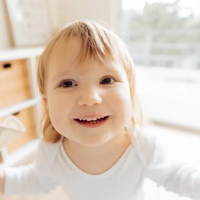 A photo of a happy, smiling toddler